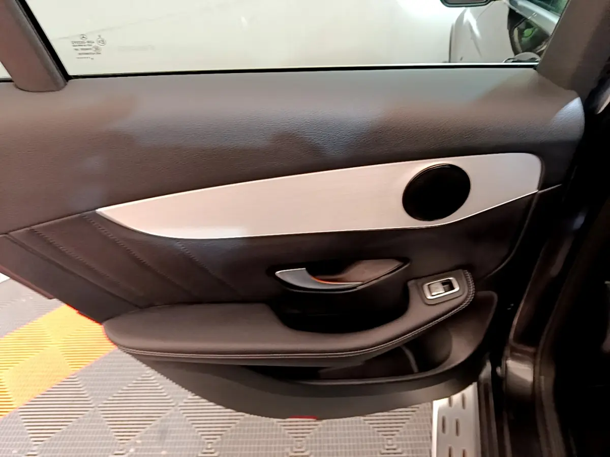 Gros plan sur la porte côté gauche du Mercedes GLC gris foncé, avec garniture noire et insert argenté mat.