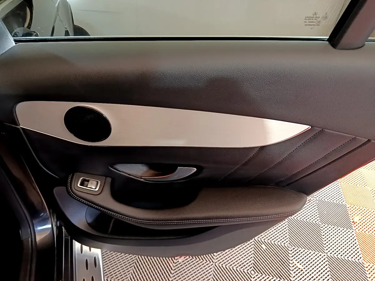 Vue rapprochée de la porte côté gauche du Mercedes GLC 300 E AMG Line 2021, avec garniture noire et insert aluminium brossé.