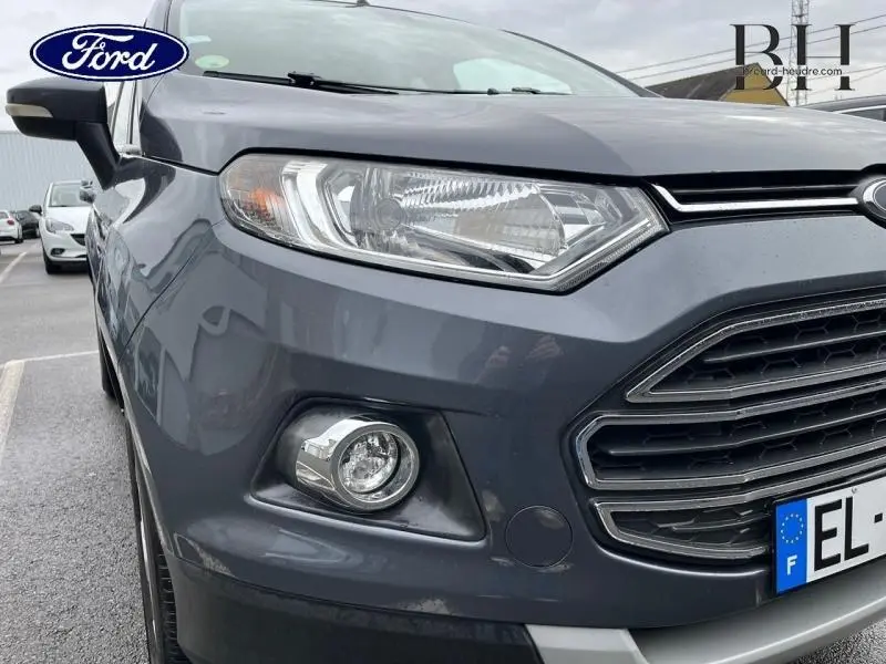 Vue rapprochée 3/4 avant gauche du Ford EcoSport 2017 gris Smoke, mettant en valeur le phare et la calandre distinctive.