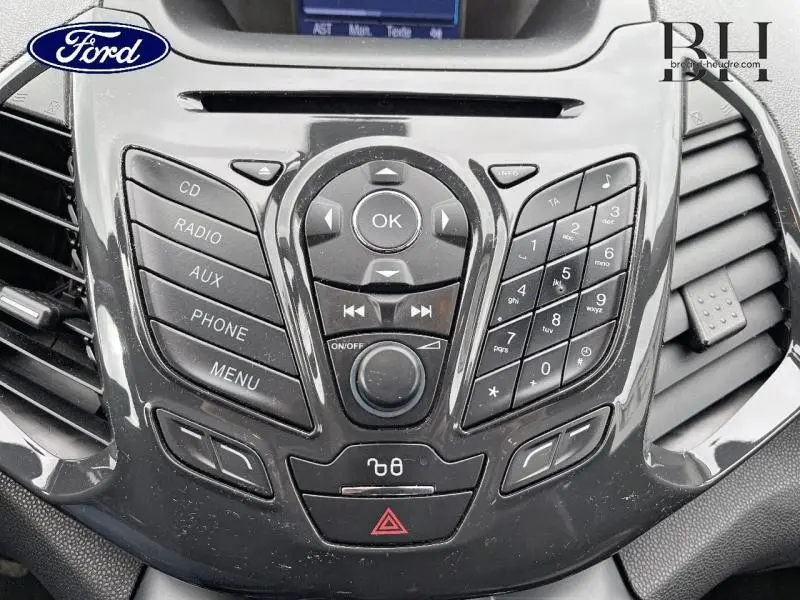 Gros plan sur la console centrale noire brillante du Ford EcoSport 2017 avec commandes audio et téléphone intégrées.