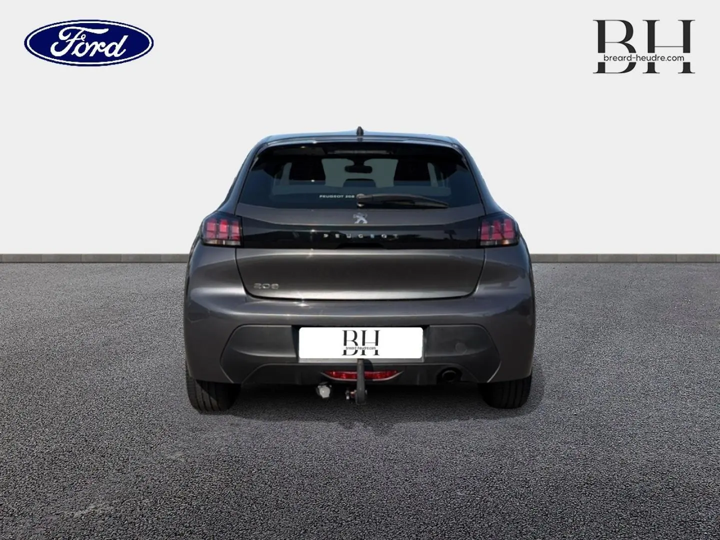 Vue arrière d'une Peugeot 208 gris Platinium avec attelage visible, sur sol goudronné et fond blanc.