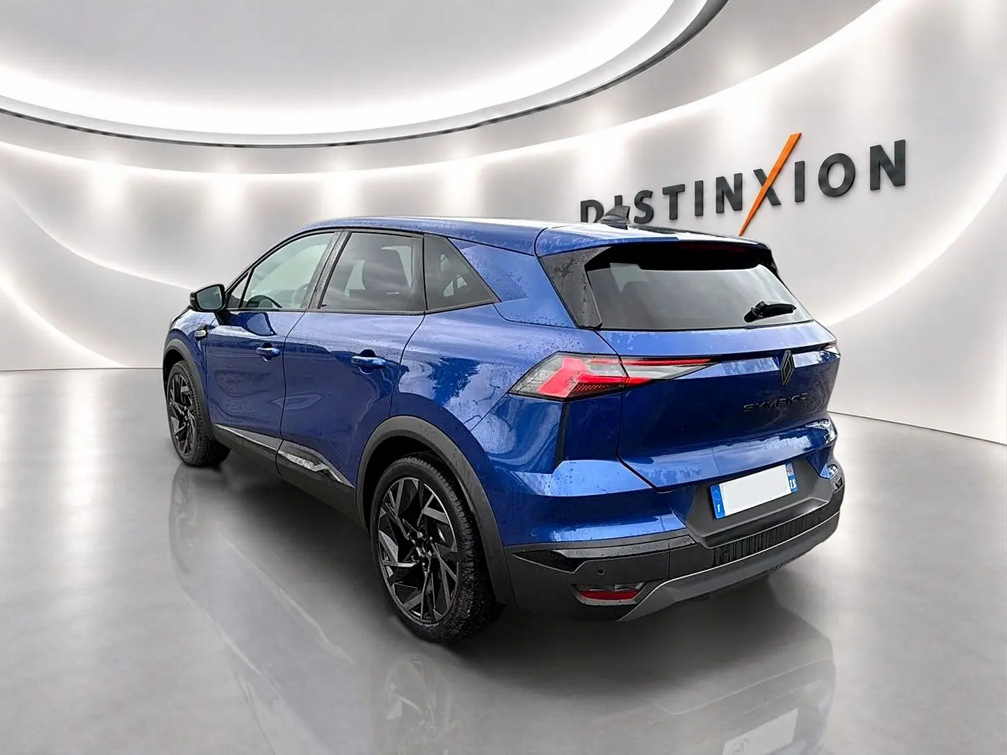 Vue 3/4 arrière droite du Renault Symbioz 2026 bleu iron avec jantes noires et feux arrière LED distinctifs.