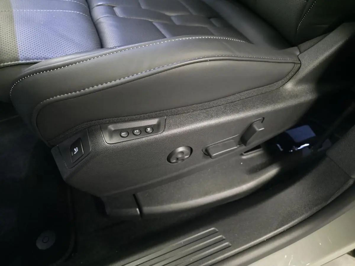 Détail du côté gauche du siège avant en cuir noir avec commandes électriques sur DS7 Crossback gris 2025.