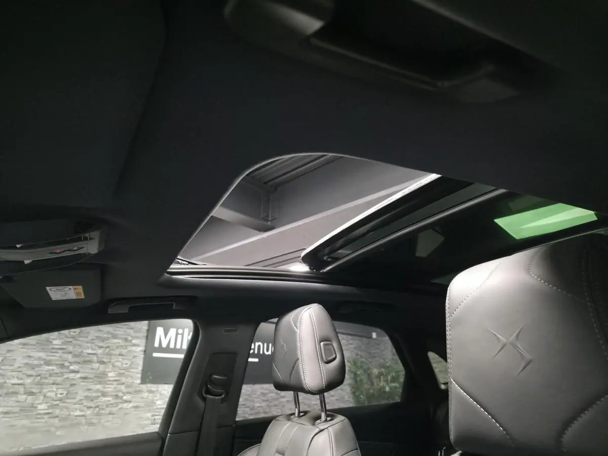 Vue intérieure du toit ouvrant panoramique et des appuie-têtes en cuir gris du DS7 Crossback 2025.