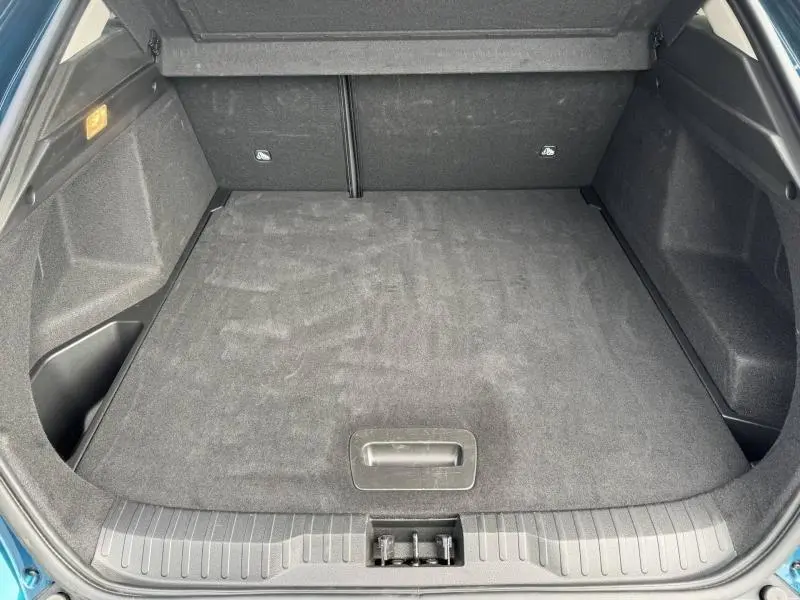 Coffre vide vu de l'arrière d'un Renault Arkana 2025 Bleu Zanzibar, montrant l'espace de chargement et le revêtement noir.