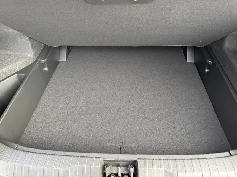 Coffre vide vu de dessus du Renault Arkana 2025, intérieur noir avec revêtement tissu et plastique.