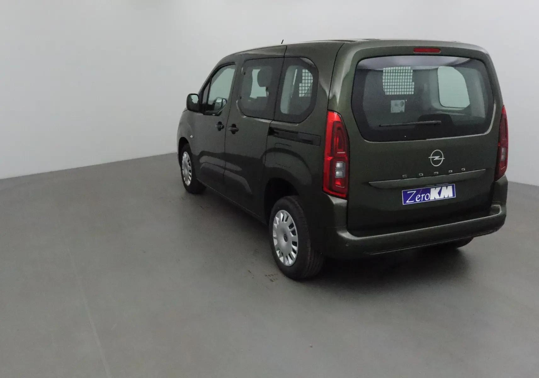 Opel Combo Life vert Sirkka vu de 3/4 arrière droit avec grille de séparation visible à l'intérieur.