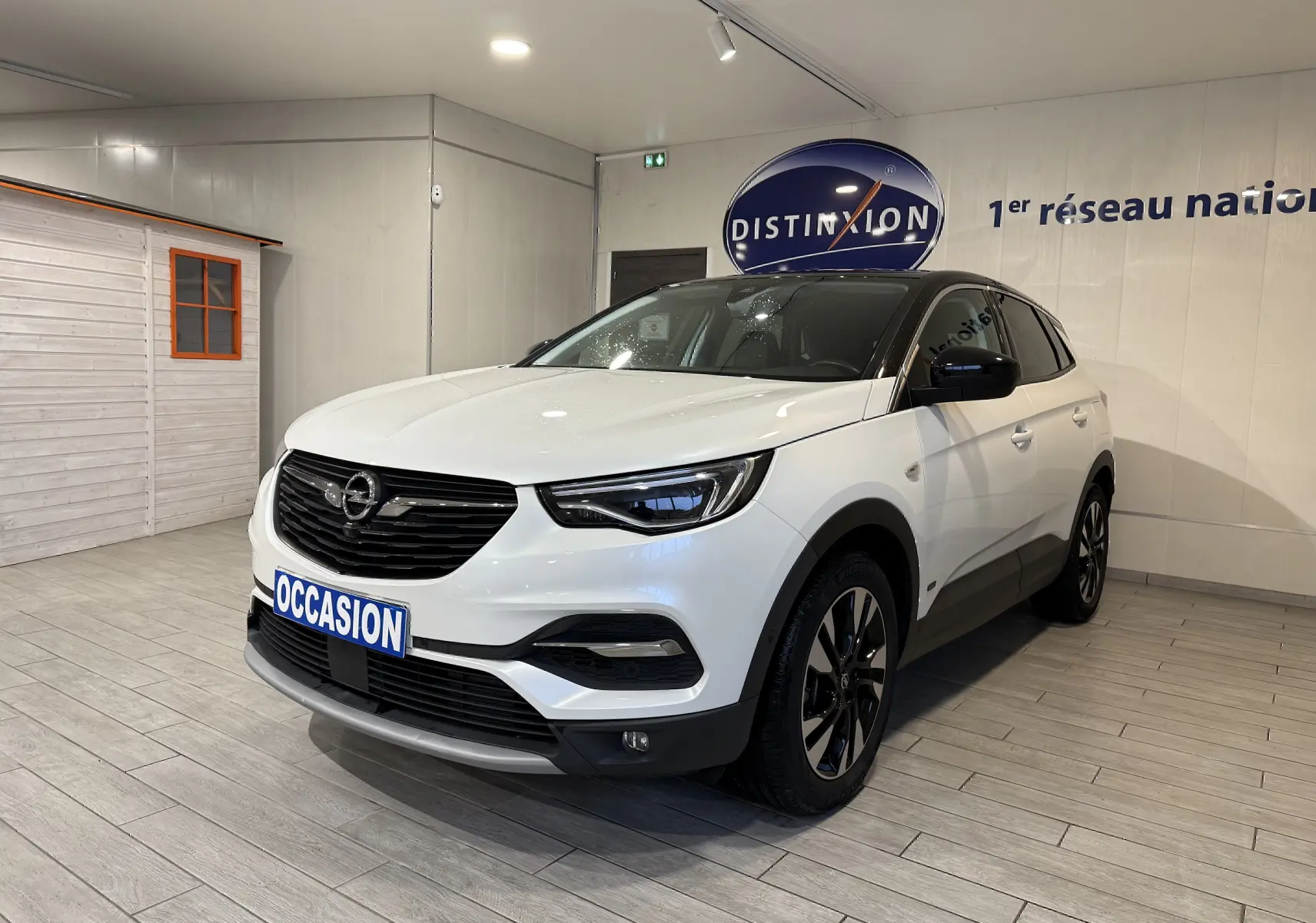 Opel Grandland X blanc en 3/4 avant droit, SUV hybride rechargeable avec jantes noires et toit noir contrasté.