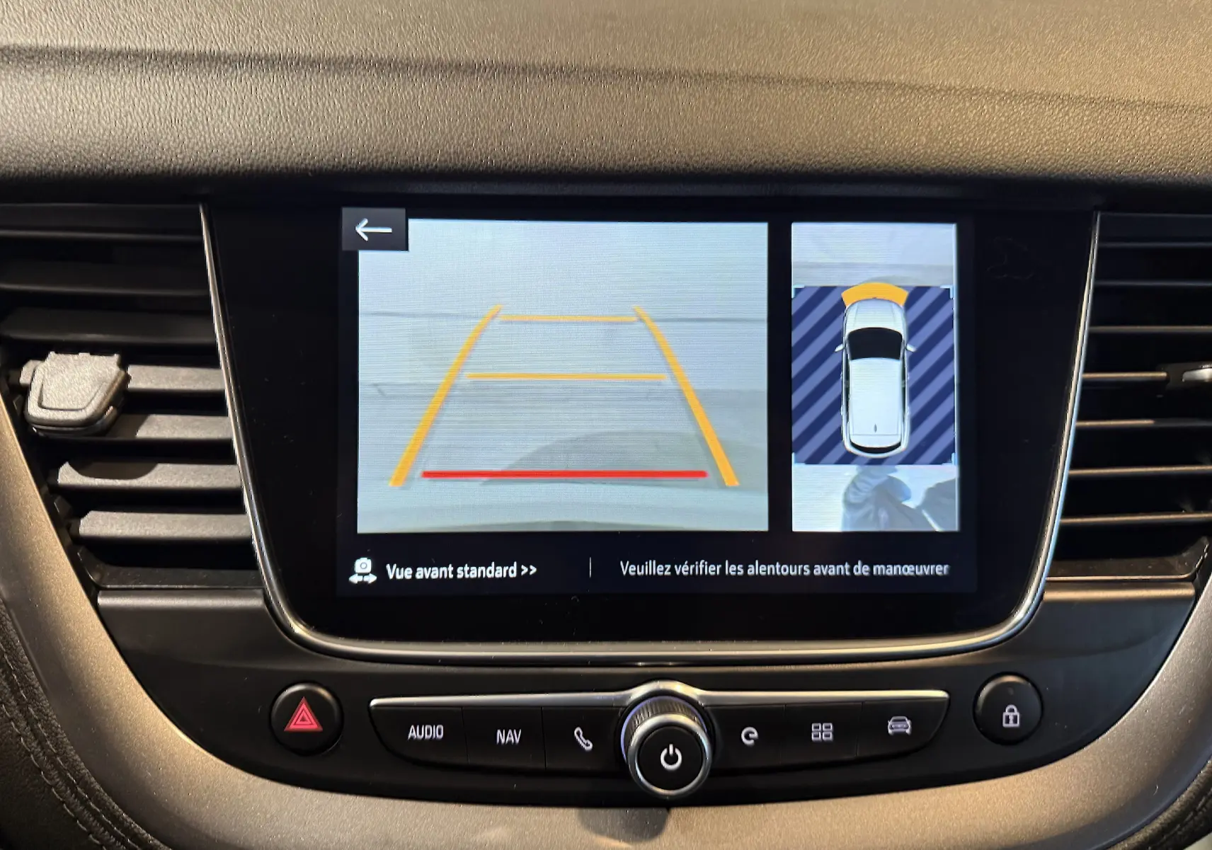 Écran central de l’Opel Grandland X blanc montrant la caméra avant et la vue 360° du véhicule en stationnement.