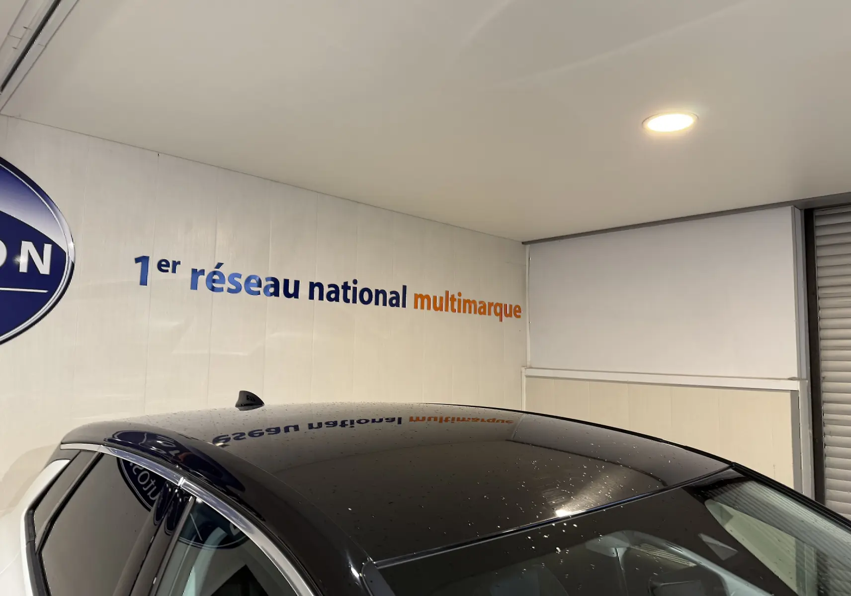 Toit noir brillant d'un Opel Grandland X blanc, vu en léger plongé intérieur avec reflet du plafond.