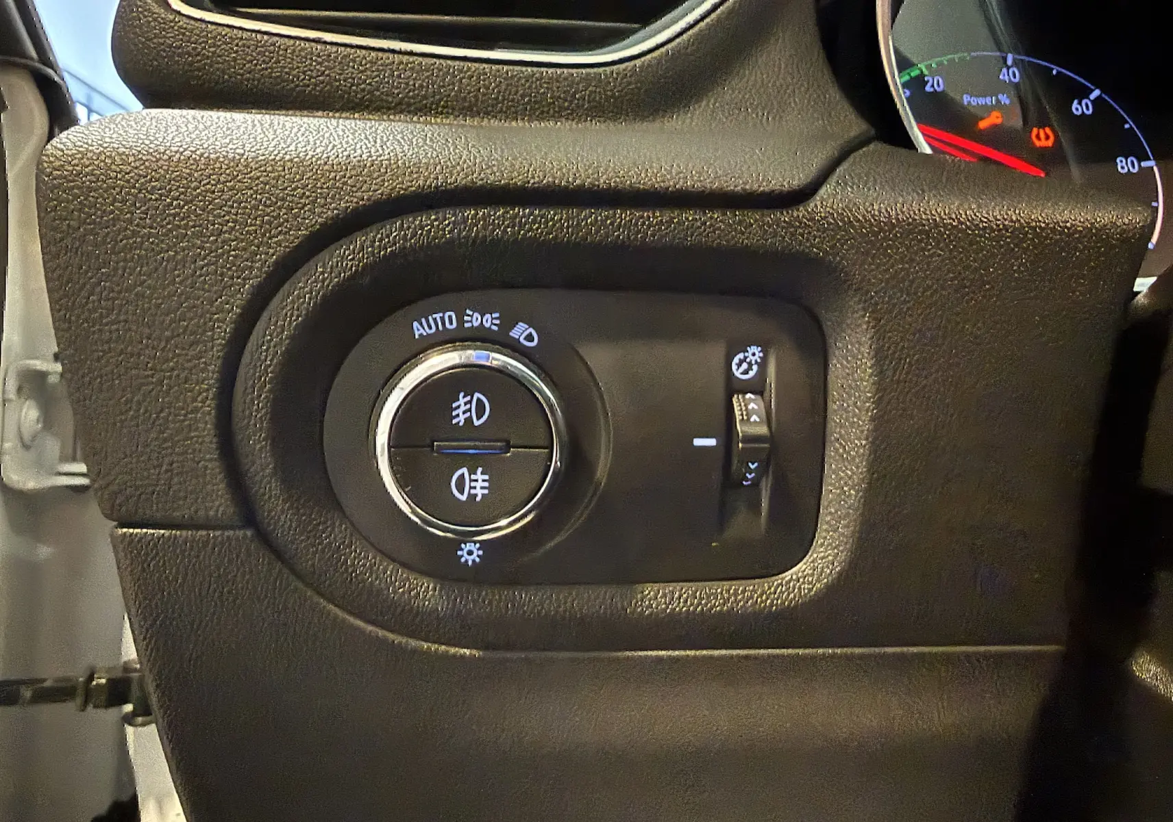 Détail du tableau de bord noir de l'Opel Grandland X 2021 montrant les commandes d'éclairage et réglage de luminosité.