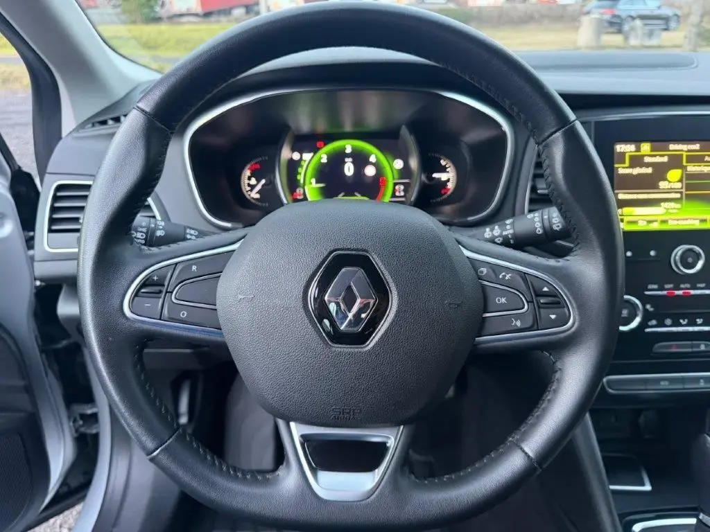 Vue centrée sur le volant noir de la Renault Mégane 2019 avec tableau de bord numérique et écran tactile à droite.