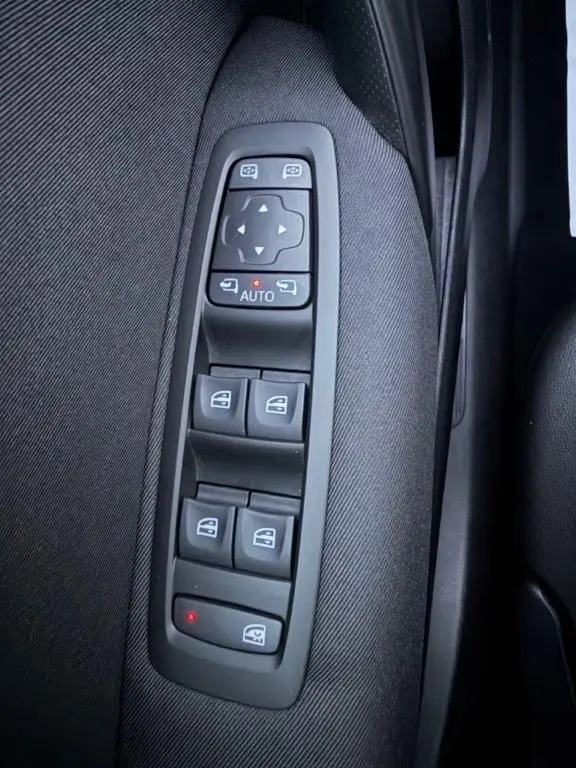 Gros plan sur les commandes de lève-vitres et rétroviseurs électriques côté gauche d'une Renault Mégane gris alu de 2019.