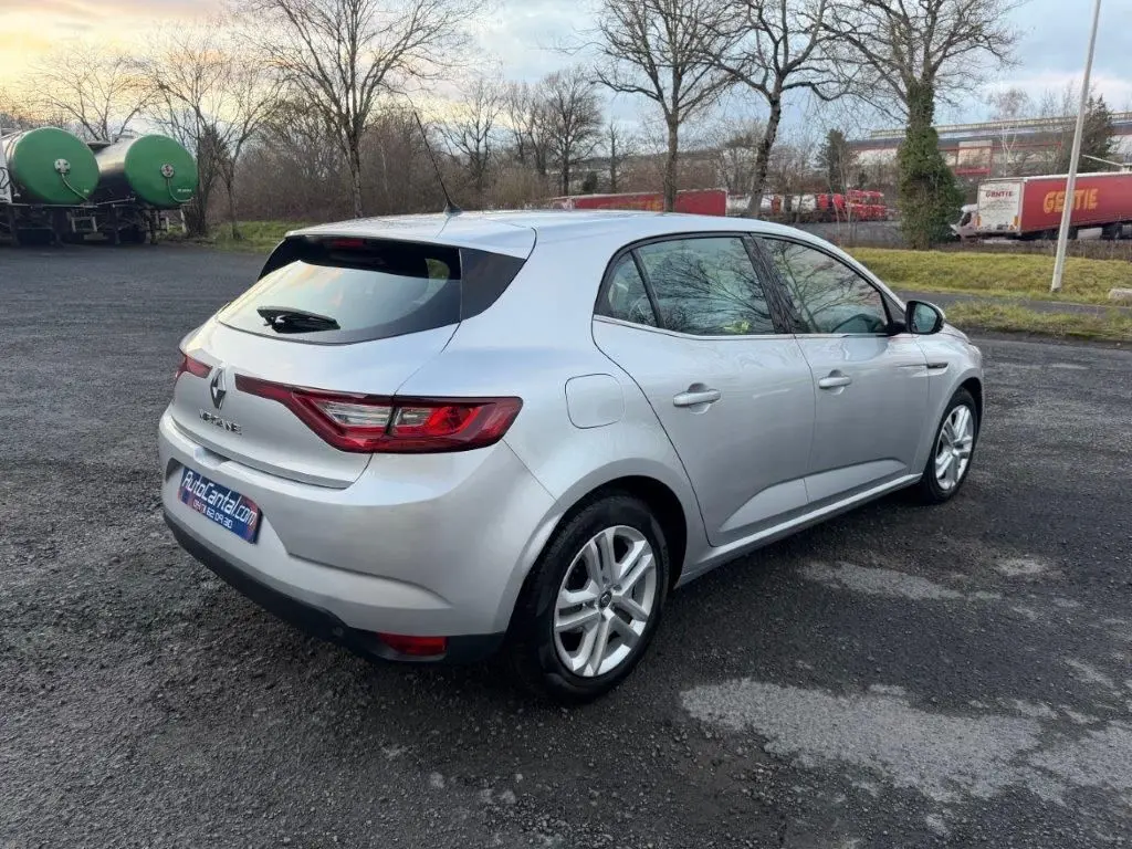 Renault Mégane gris alu vue 3/4 arrière droit sur parking, avec feux arrière LED et jantes alliage visibles.