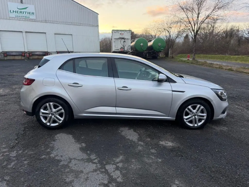 Vue de profil côté gauche d'une Renault Mégane gris alu 2019, avec jantes alliage et lignes épurées.