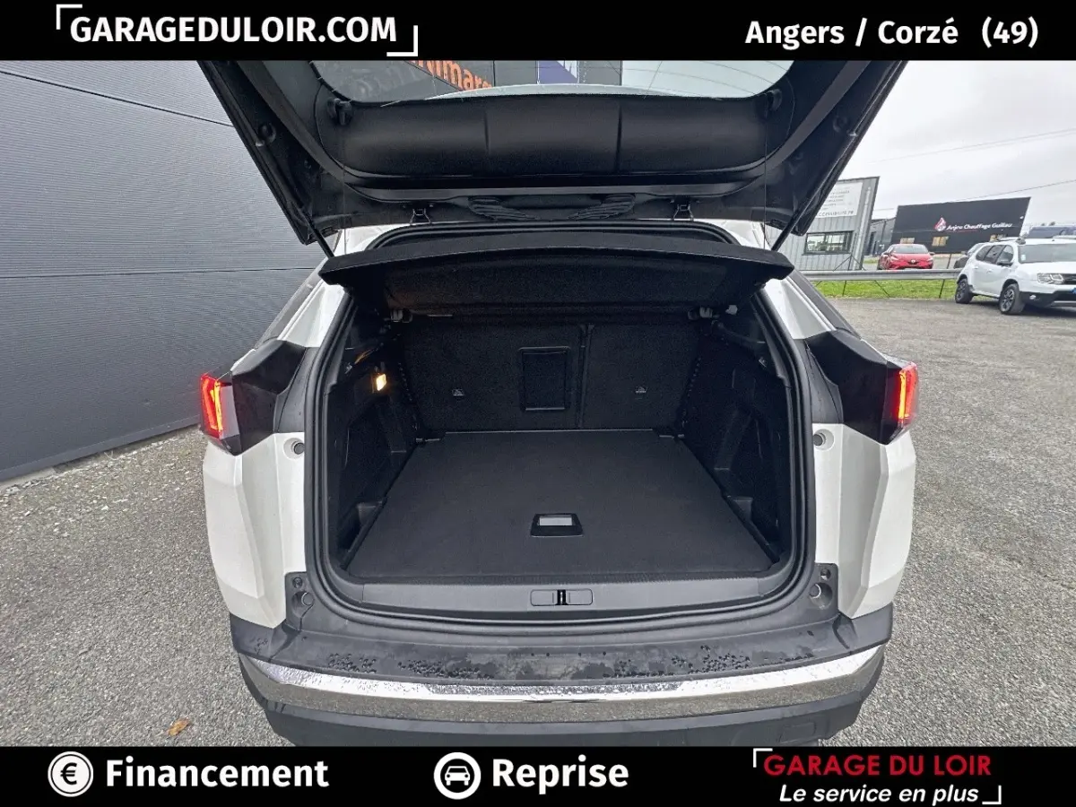 Vue arrière du coffre ouvert d'un Peugeot 3008 blanc, mettant en valeur l'espace de chargement vide et l'éclairage intérieur.