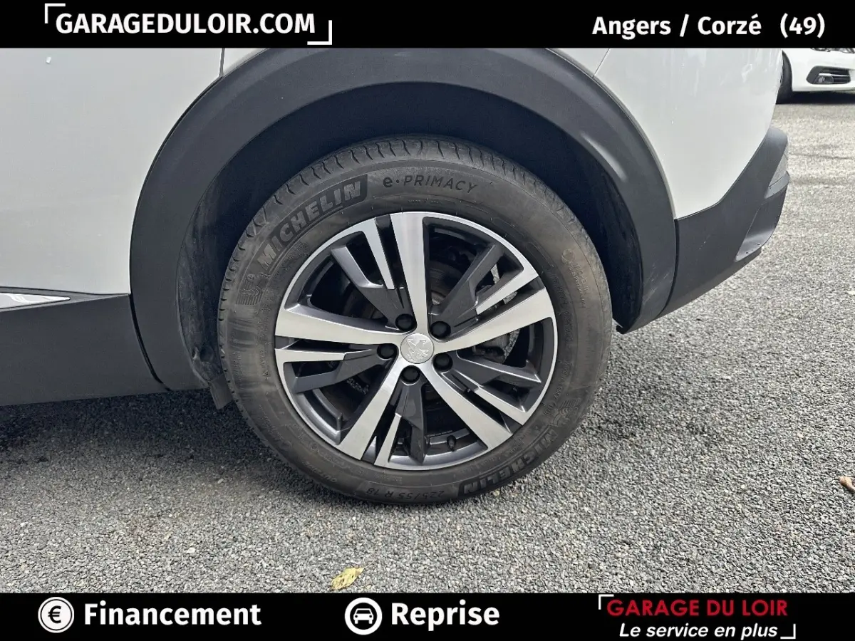 Gros plan sur la roue arrière droite d'un Peugeot 3008 blanc avec jante alliage et pneu Michelin e-Primacy.