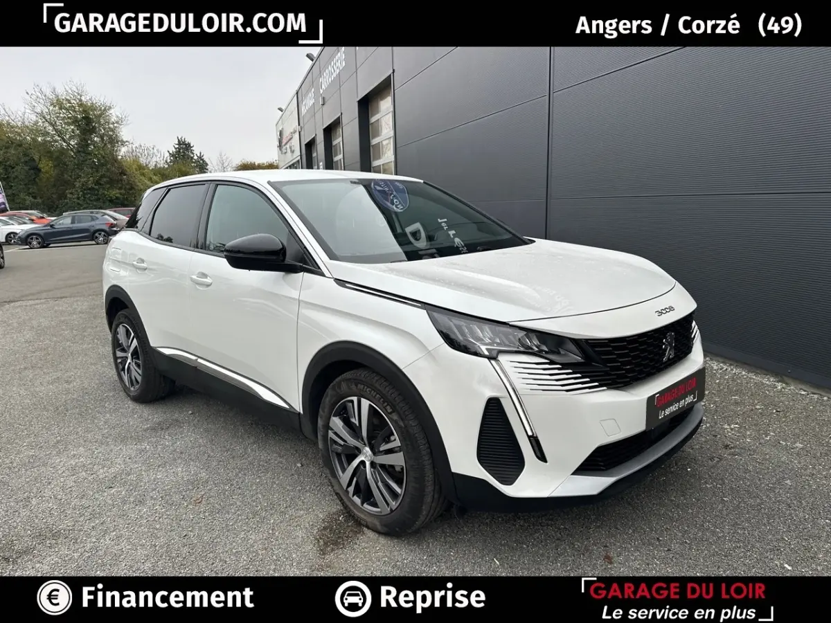 Vue 3/4 avant d’un Peugeot 3008 blanc avec calandre noire et feux LED distinctifs, stationné devant un bâtiment gris.