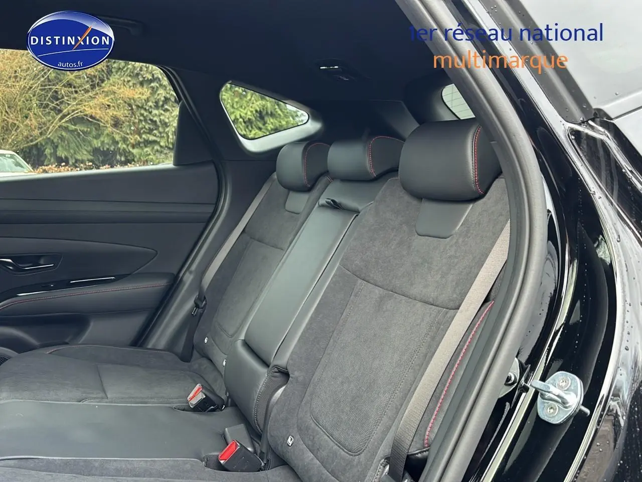 Vue intérieure côté droit sur la banquette arrière noire avec surpiqûres rouges du Hyundai Tucson 2026 hybride N Line.
