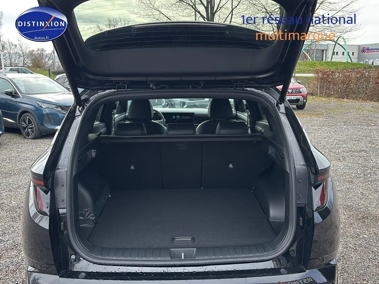 Vue arrière du coffre ouvert d'un Hyundai Tucson noir 2026, intérieur spacieux et banquette rabattable visible.