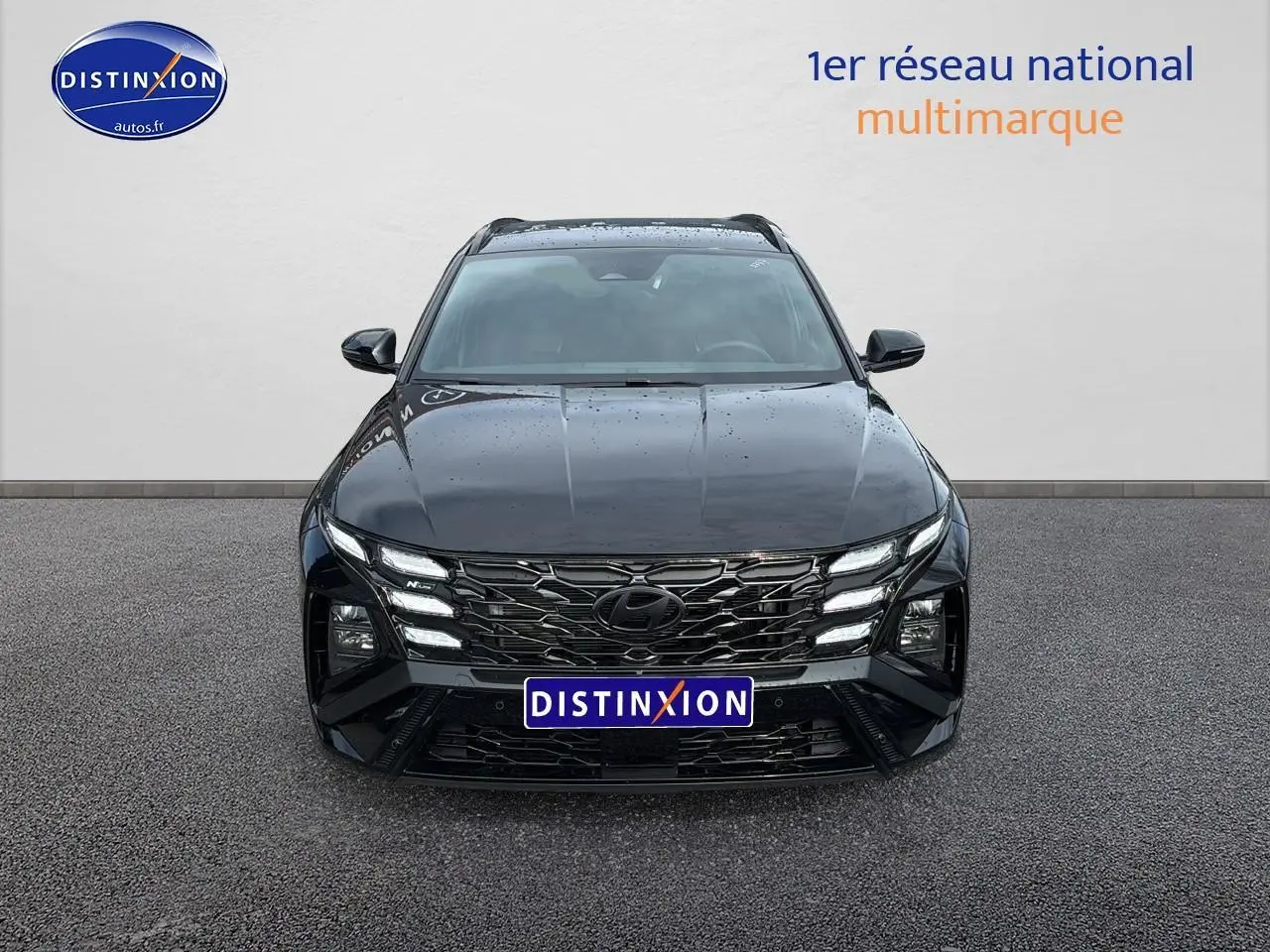 Vue frontale d’un Hyundai Tucson noir 2026 avec calandre glossy black et feux LED distinctifs.