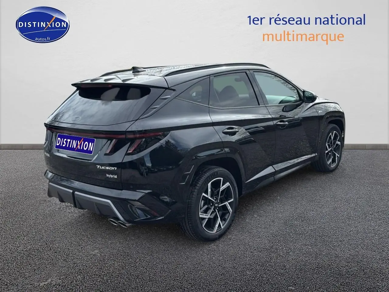 Vue 3/4 arrière droite du Hyundai Tucson noir hybride avec jantes alliage 19 et feux arrière LED continus.