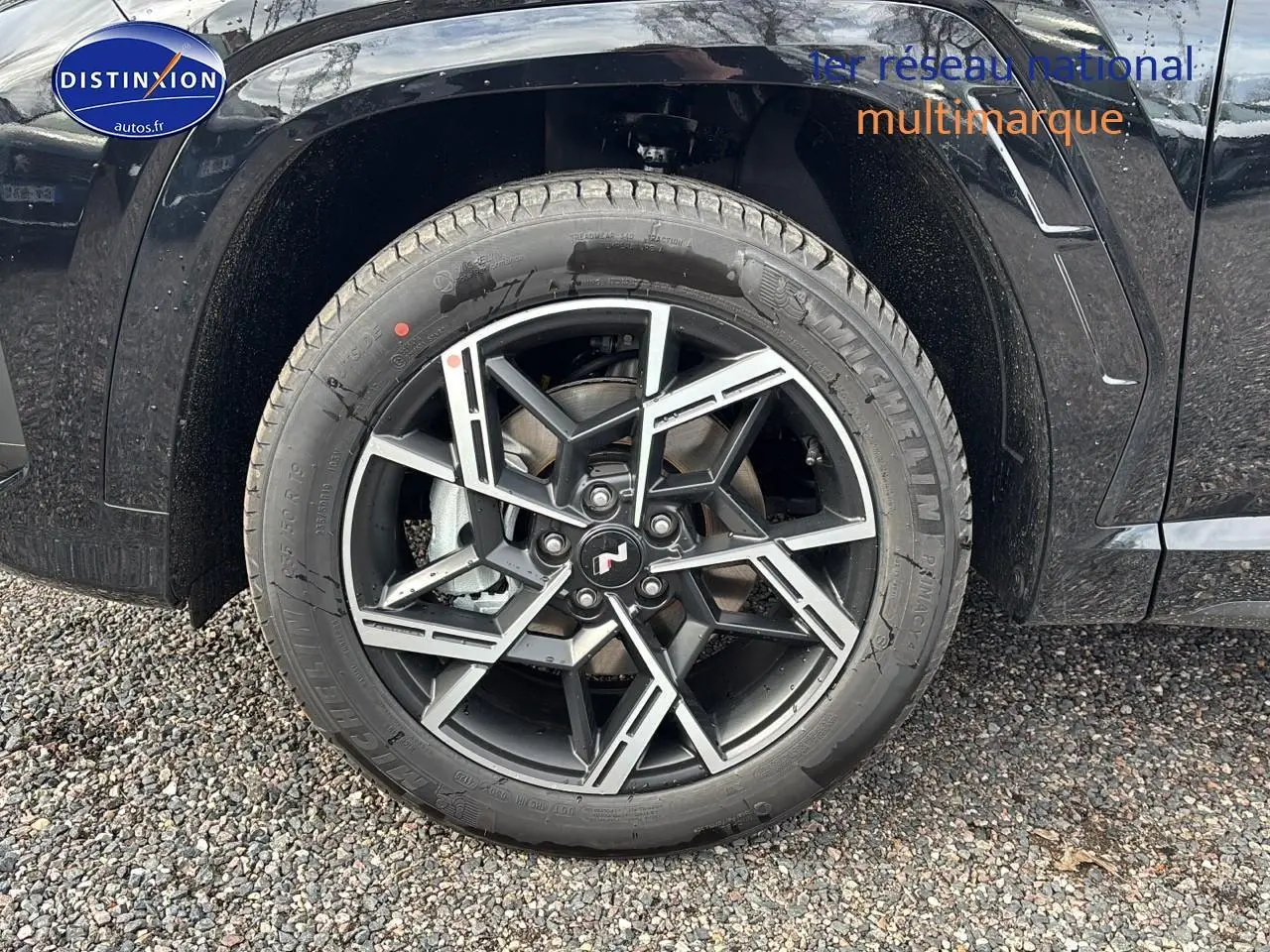 Gros plan sur la jante alliage 19 pouces noire et argent du côté avant gauche du Hyundai Tucson noir 2026.