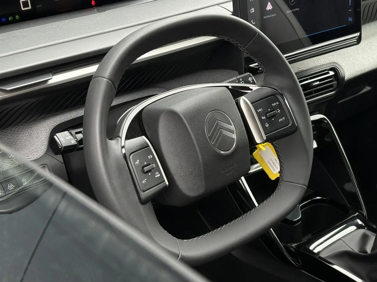 Vue rapprochée du volant noir de la Citroën C3 2025 avec commandes intégrées et écran tactile central visible.