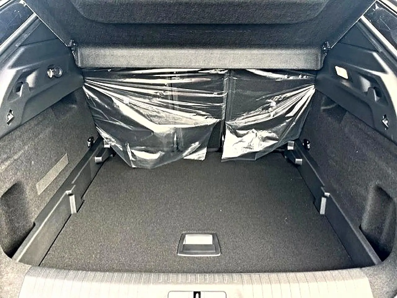 Coffre ouvert du Peugeot 3008 gris titane, vue de l'arrière montrant un espace de rangement propre et spacieux.