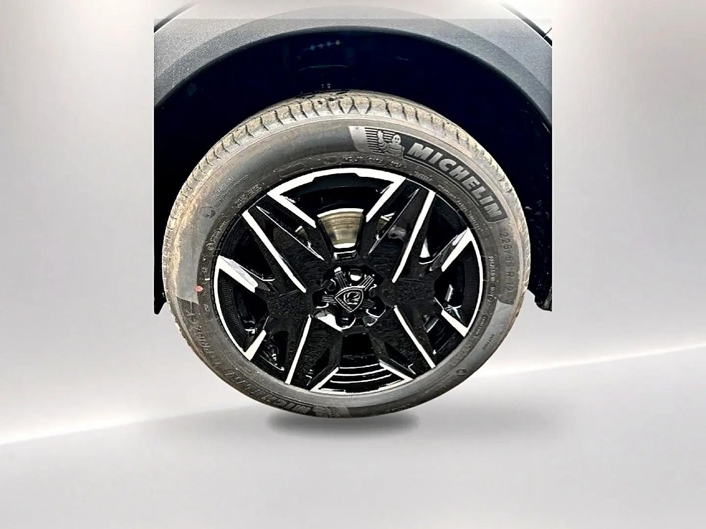Gros plan sur la roue avant droite du Peugeot 3008 gris titane, jante alu noire et argentée avec pneu Michelin.