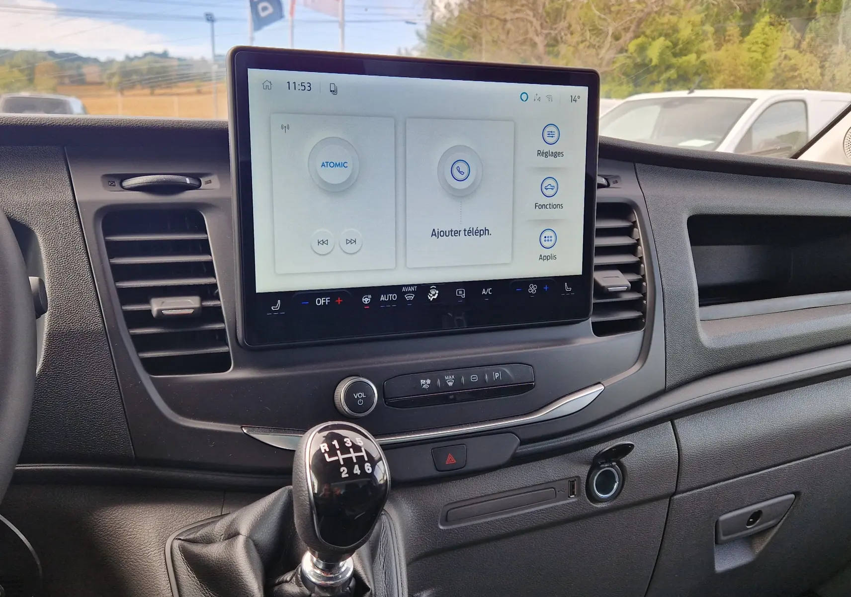 Vue intérieure centrée sur la console centrale du Ford Transit Châssis Cabine blanc avec écran tactile et levier de vitesse manuel.
