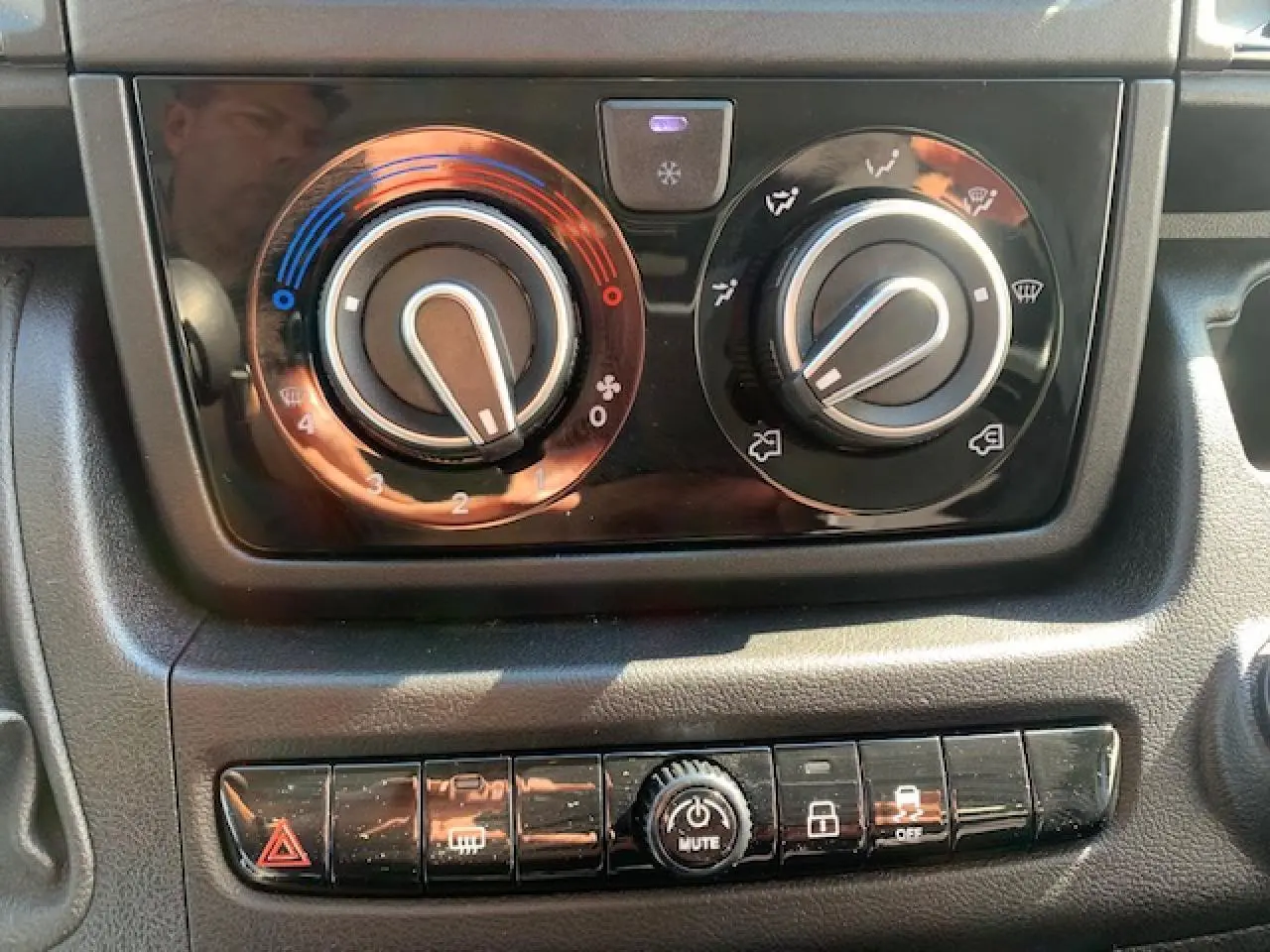 Gros plan sur les commandes de climatisation et les boutons de fonction du tableau de bord du Fiat Ducato Fourgon blanc 2022.