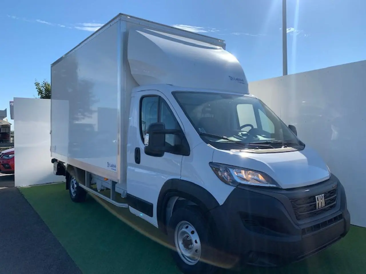 Fiat Ducato Fourgon blanc en 3/4 avant droit, avec caisse capucine et jantes acier 16 pouces visibles.