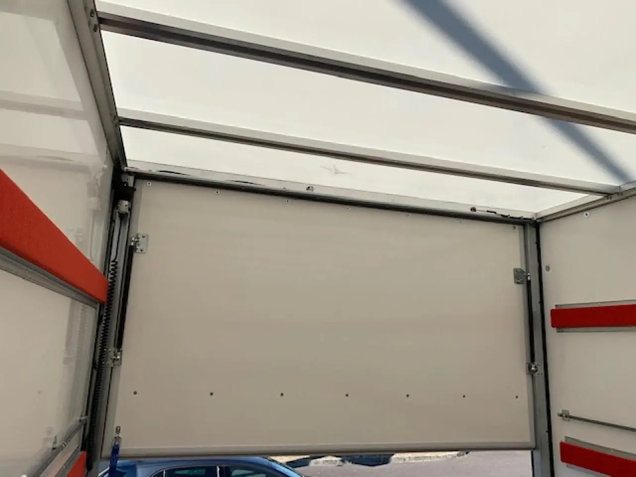 Intérieur du fourgon blanc Fiat Ducato 2022, vue sur la paroi arrière avec renforts rouges et toit translucide.
