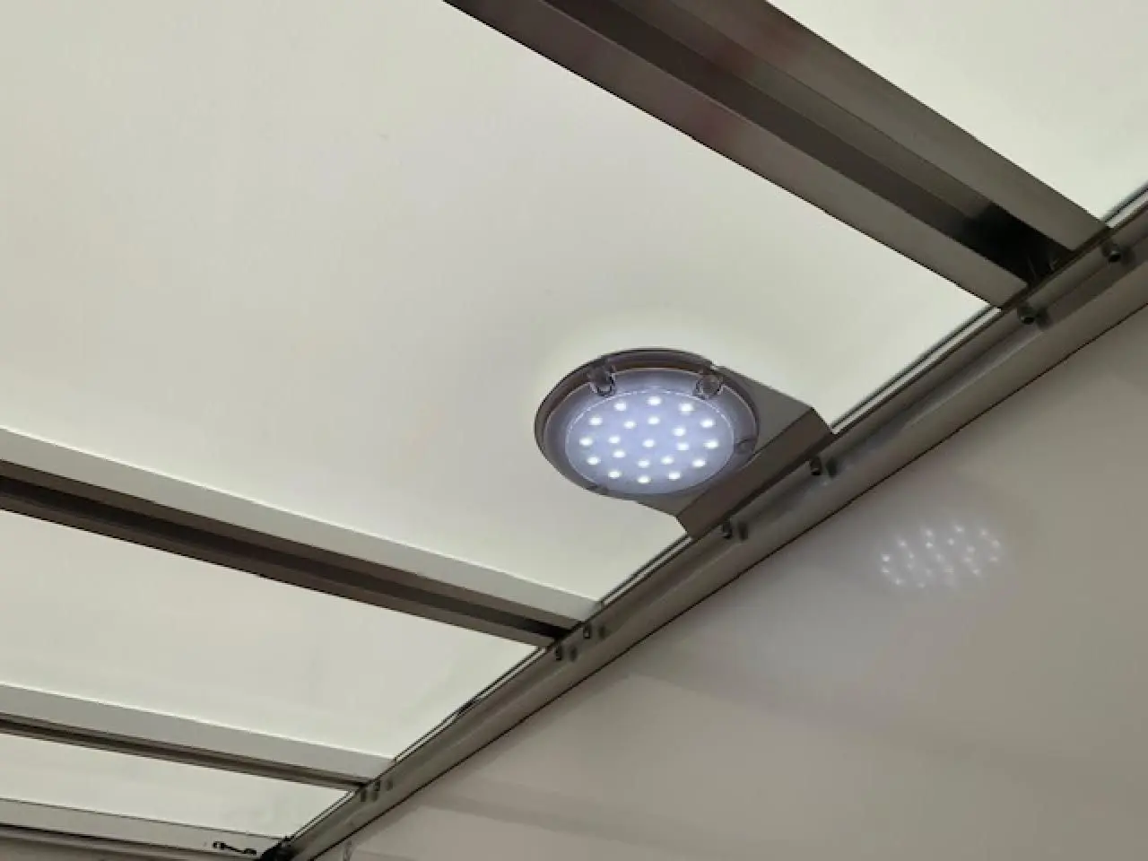 Vue intérieure du toit blanc du FIAT Ducato Fourgon 2022 avec éclairage LED circulaire fixé sur la structure métallique.