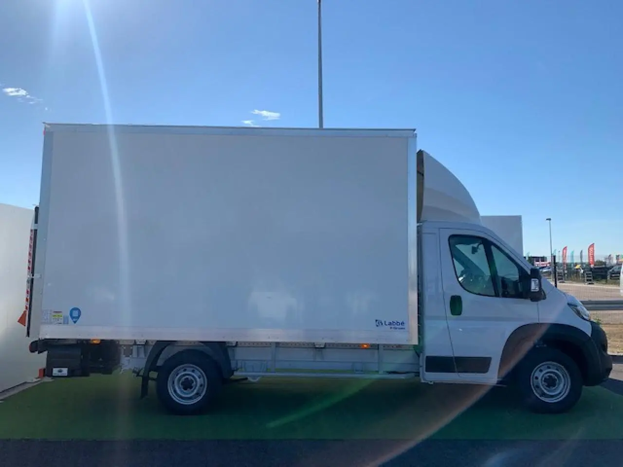 Fiat Ducato Fourgon blanc vu de profil côté gauche, avec caisse fourgon et hayon arrière visible.