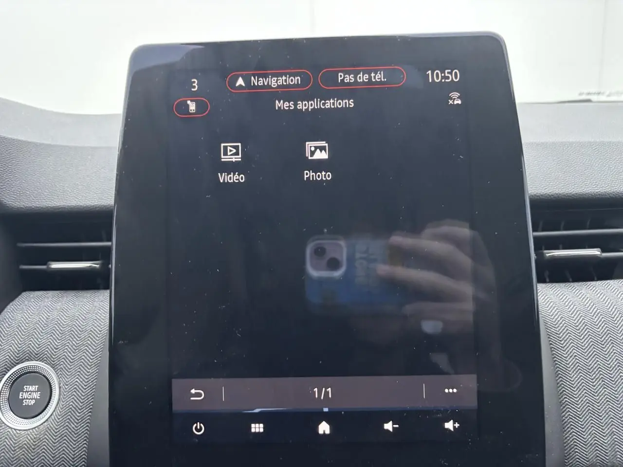 Vue rapprochée de l'écran tactile central du tableau de bord de la Renault Clio rouge flamme, affichant le menu navigation.