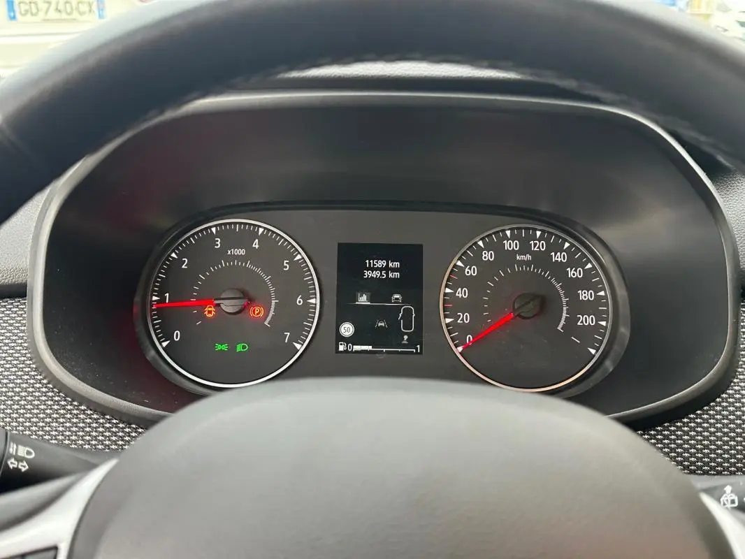 Vue rapprochée du tableau de bord de la Dacia Sandero blanc 2024, avec compte-tours, compteur et écran central allumé.