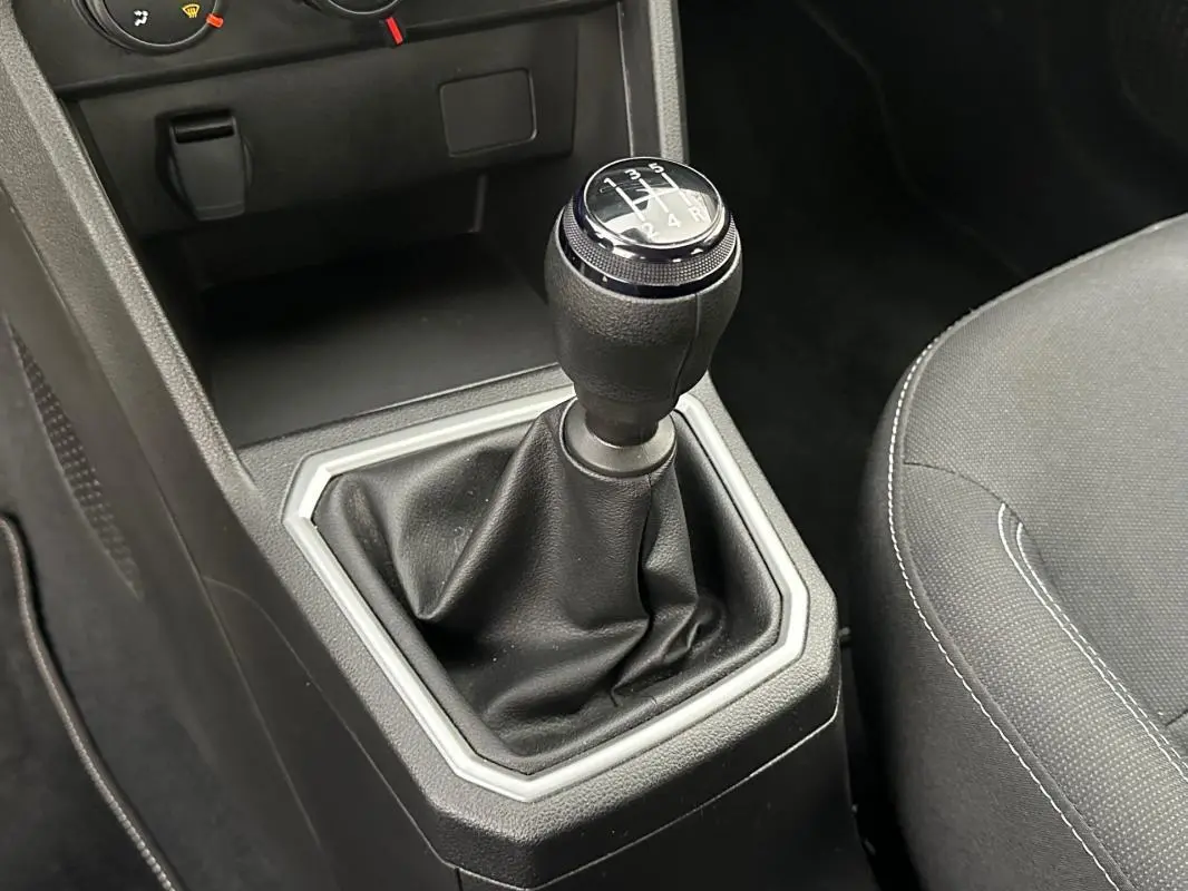 Gros plan sur le levier de vitesses manuel noir de la Dacia Sandero TCe 90 Expression 2024, intérieur gris.