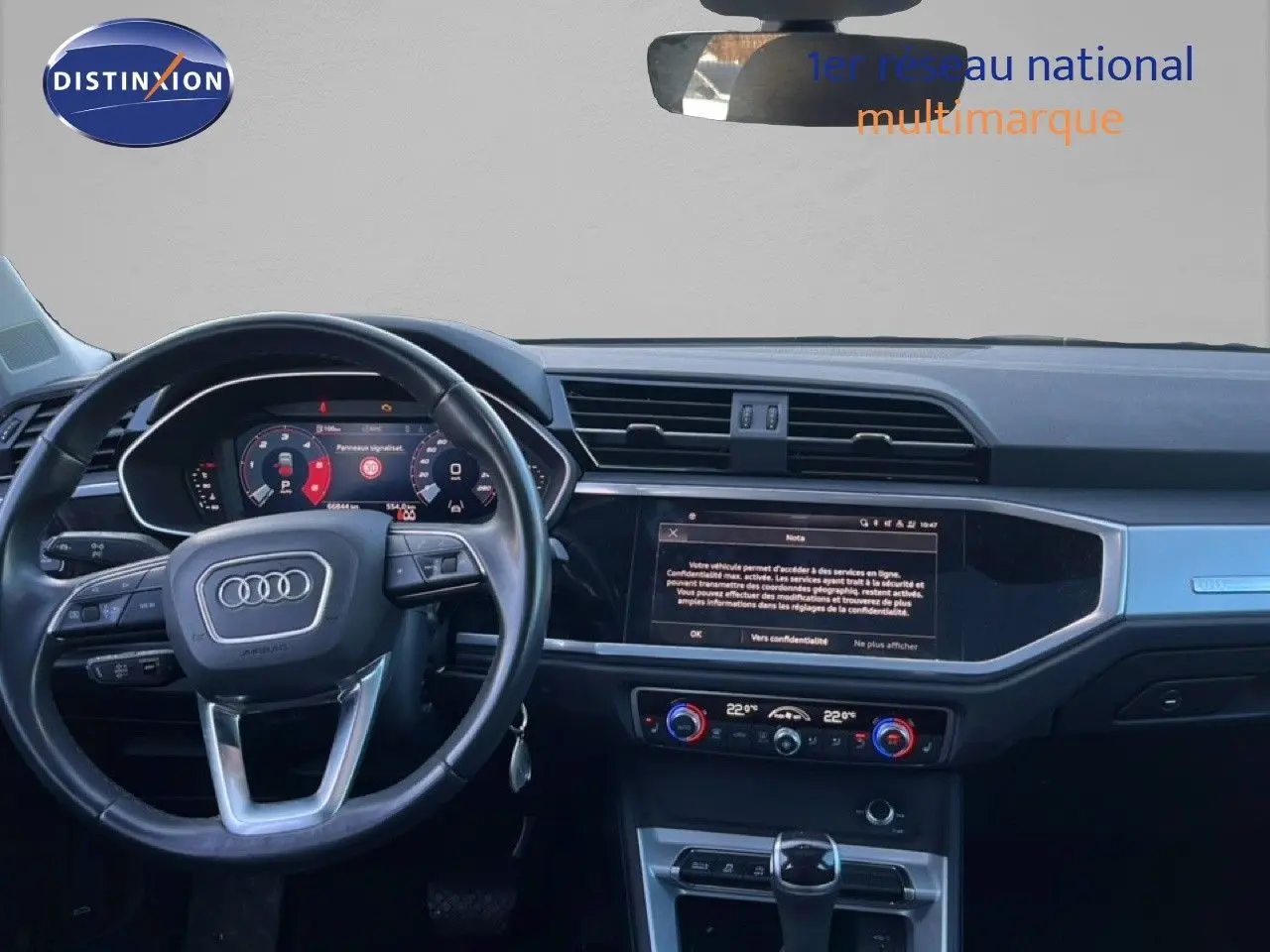 Vue intérieure de l'Audi Q3 Sportback 2022, tableau de bord et volant noir avec écran tactile central allumé.