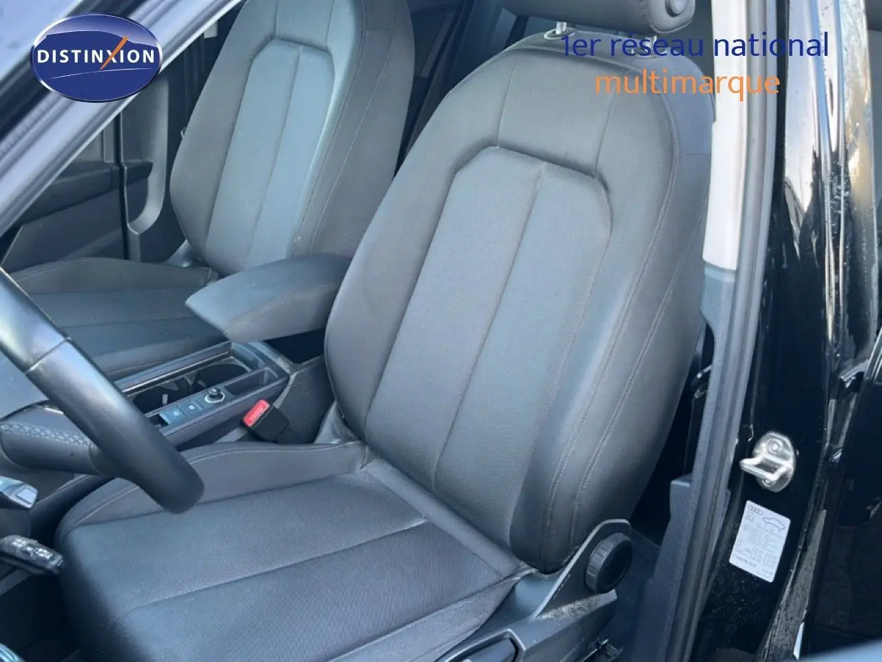 Vue intérieure sur les sièges avant en tissu gris foncé d’un Audi Q3 Sportback noir mythic avec portière ouverte côté gauche.