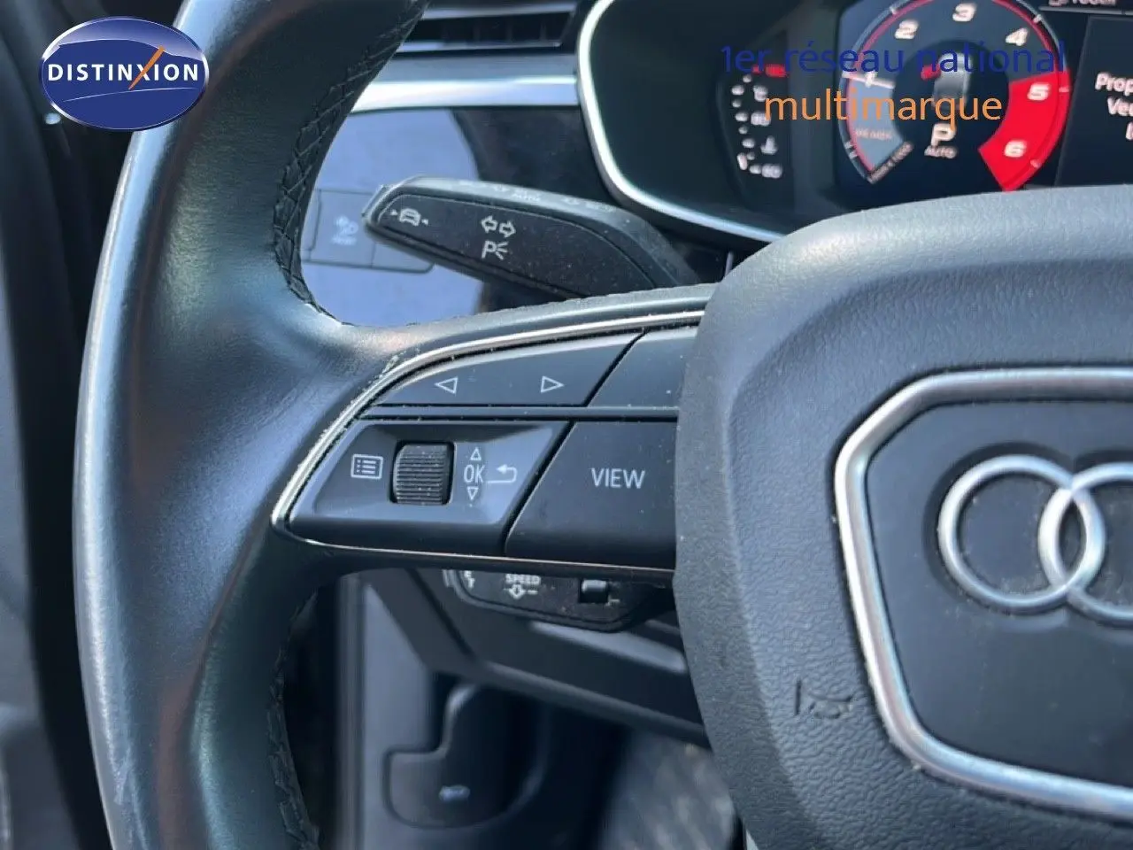 Gros plan sur le volant noir de l’Audi Q3 Sportback 2022 avec commandes multifonctions et tableau de bord numérique.