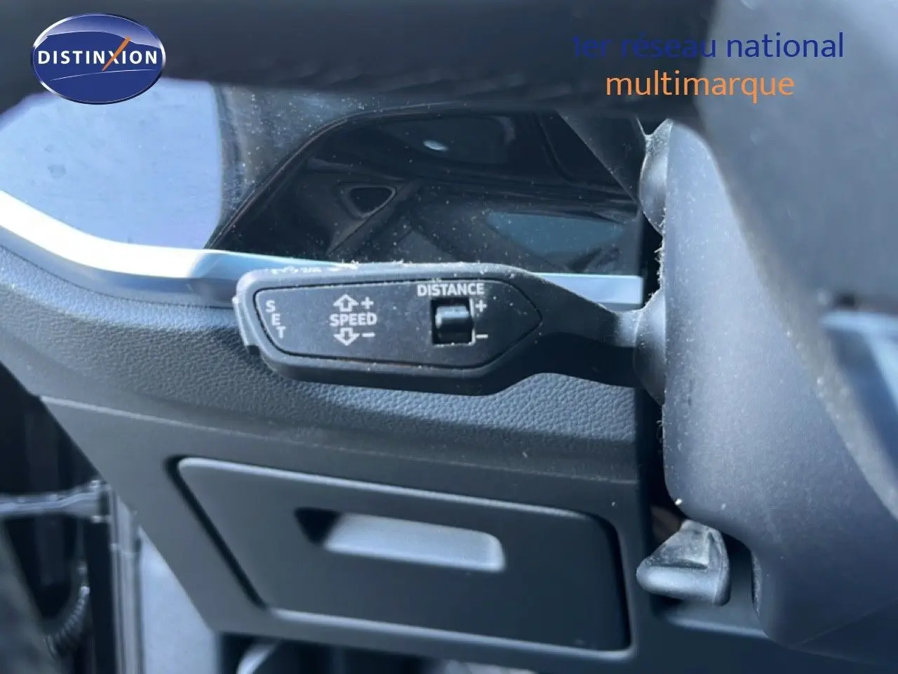 Gros plan sur la commande de régulateur de vitesse à gauche du volant dans l’Audi Q3 Sportback noir mythic 2022.