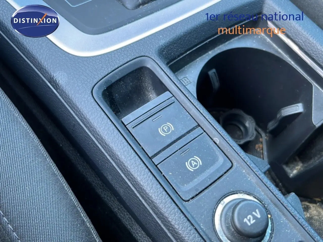 Gros plan sur la console centrale de l’Audi Q3 Sportback noir mythic, montrant les commandes de frein à main et prise 12V.