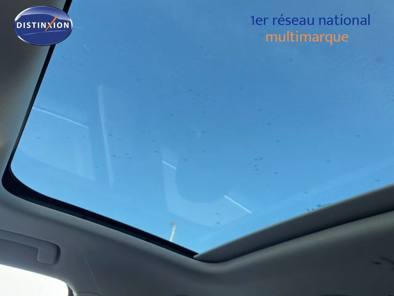 Toit panoramique ouvrant du SUV Audi Q3 Sportback 35 2.0 TDI noir mythic vu de l'intérieur vers le ciel bleu.