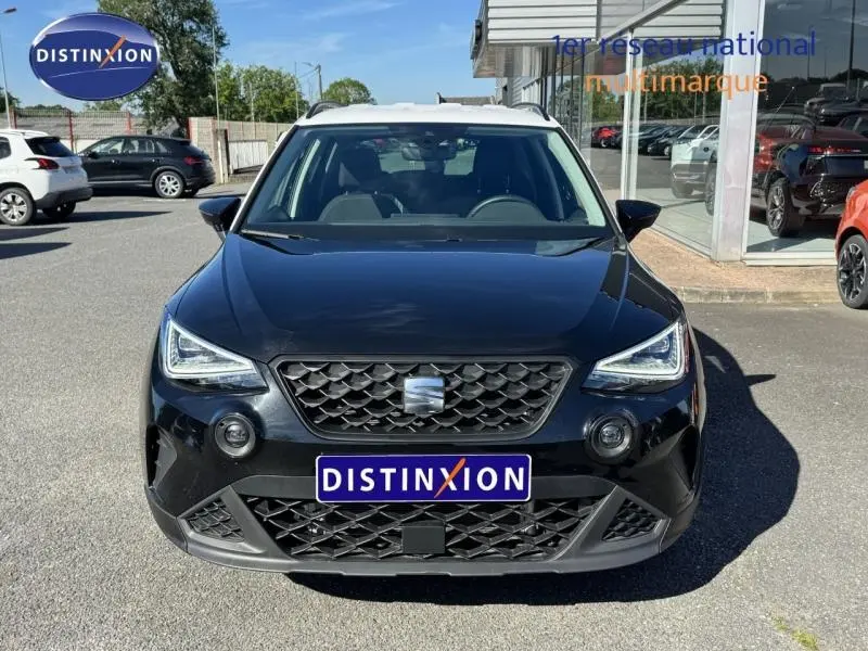 Vue avant d'un SEAT Arona 2025 noir Minuit Métal avec toit blanc Candy, calandre et phares LED distinctifs.
