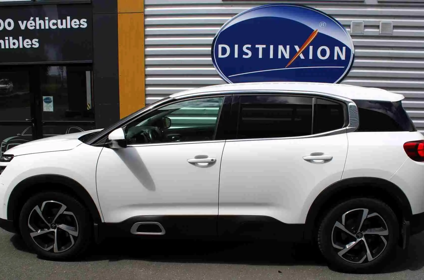 Vue de profil côté gauche d'un Citroën C5 Aircross blanc avec jantes alliage et attelage visible à l'arrière.