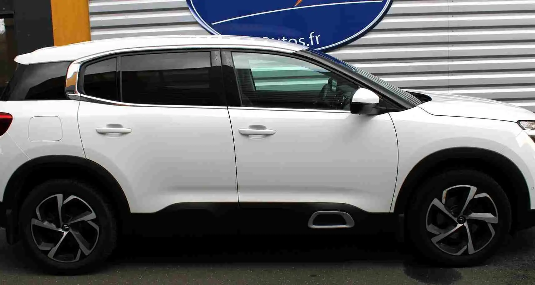 Vue de profil côté gauche d'un Citroën C5 Aircross blanc de 2020 avec jantes noires et grises, et attelage visible.