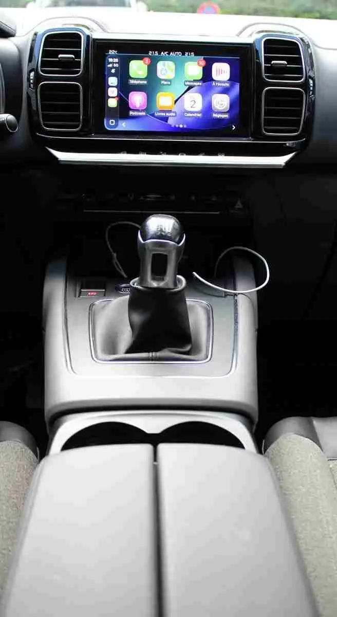Vue rapprochée de la console centrale du Citroën C5 Aircross blanc, avec levier de vitesse manuel et écran tactile multimédia.