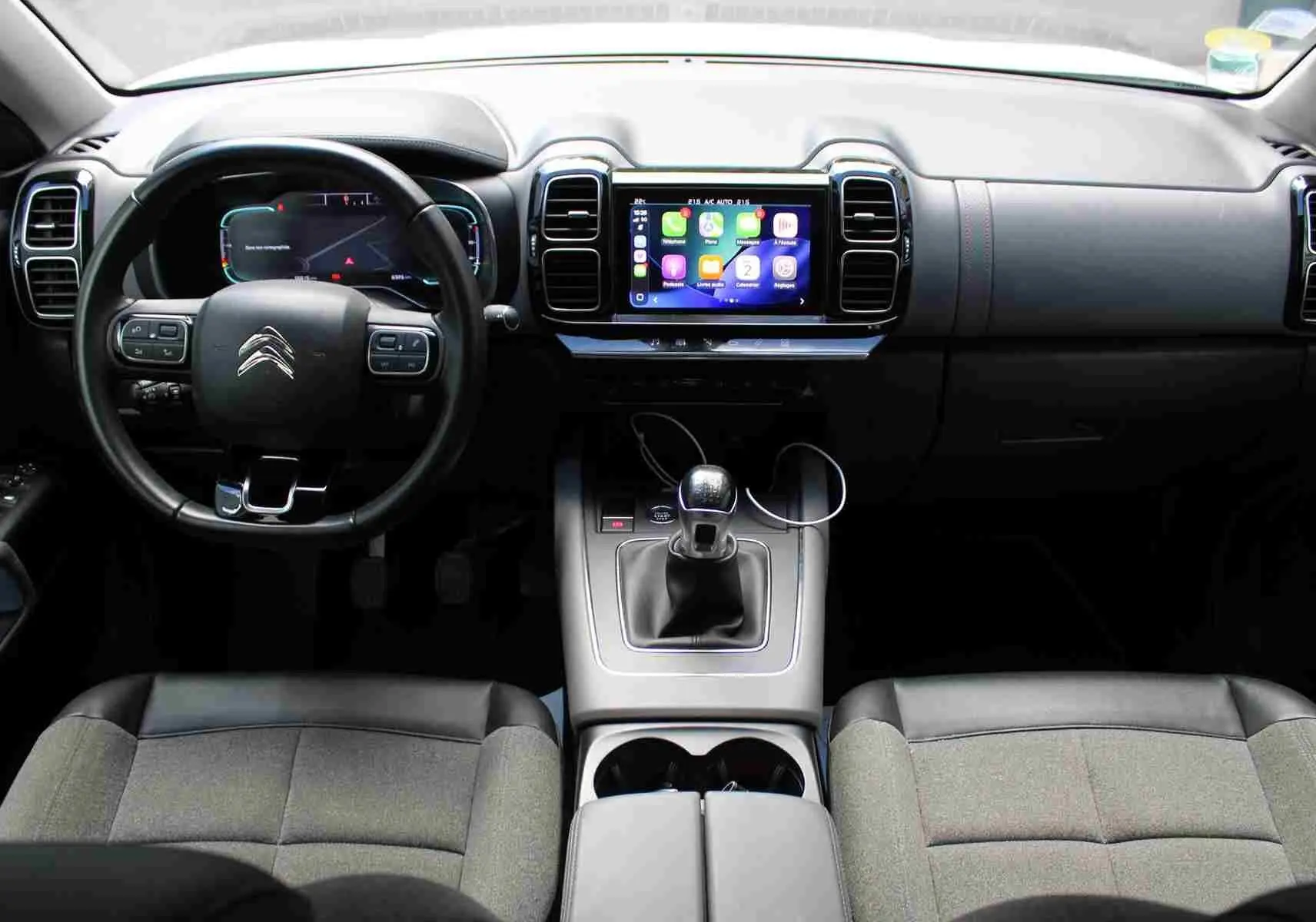 Vue intérieure avant du Citroën C5 Aircross Shine 2020, tableau de bord noir avec écran tactile et levier de vitesses manuel.